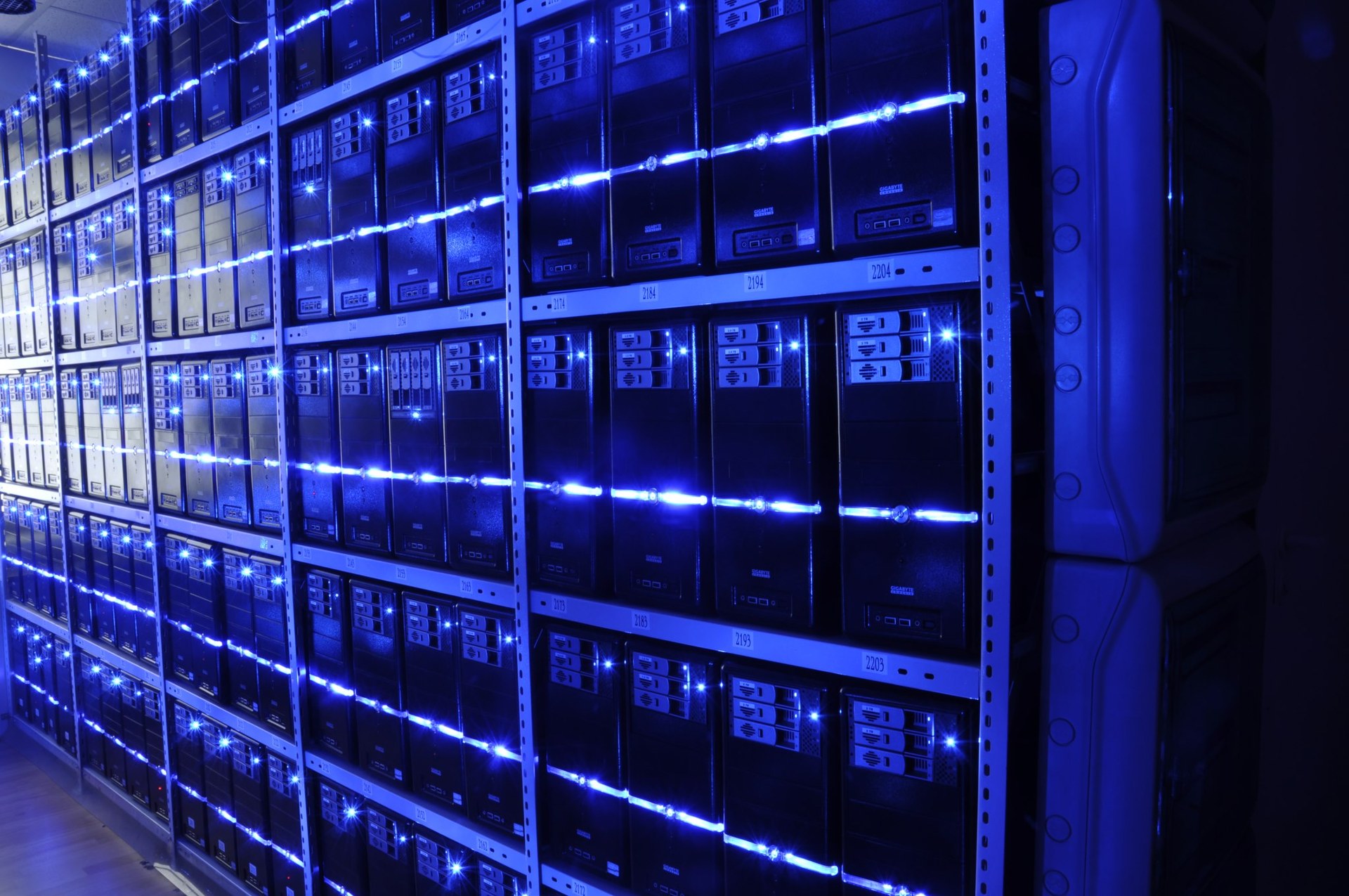 Rows of server racks lit with blue LED strips in a data centre