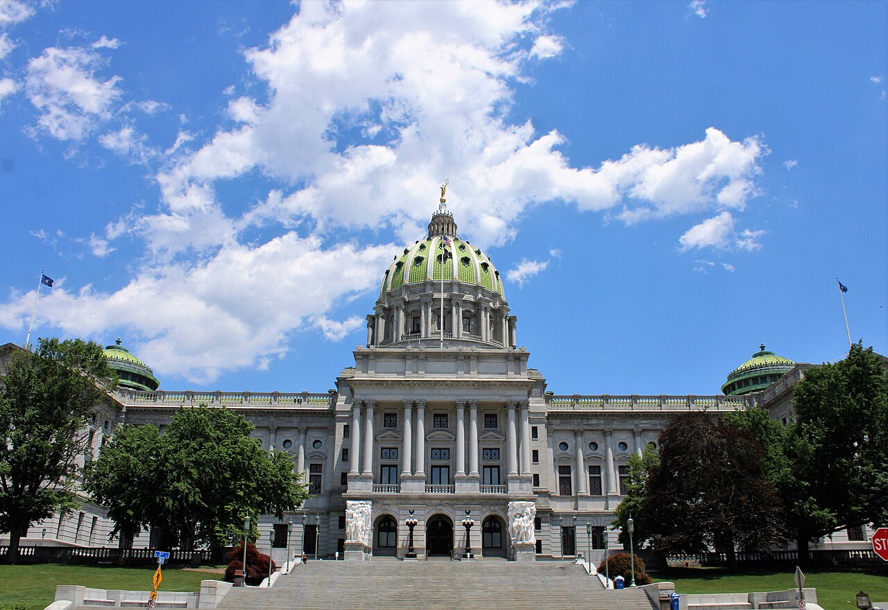 Pennsylvania State Capitol in Harrisburg with its green dome under a blue sky with white clouds