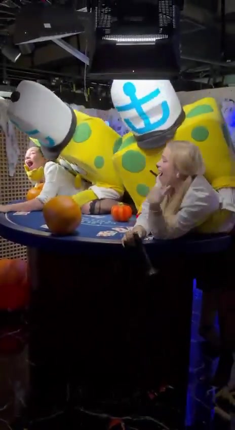 Two people in SpongeBob costumes at a live blackjack table as a dealer reacts